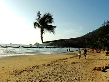 People on beach against clear sky