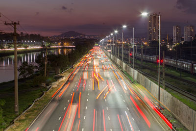 Beggining the night, bright lights and vehicles in transit. sao paulo city highway beside the river.