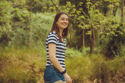 Portrait of smiling young woman standing on land