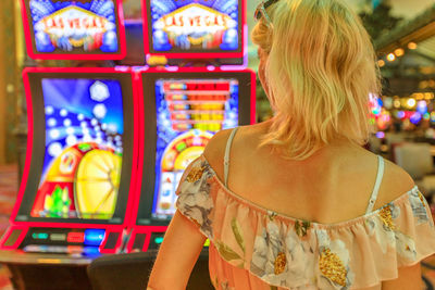 Rear view of woman standing in casino