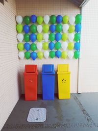 Multi colored pencils on tiled floor against wall