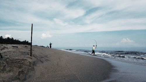 People on beach against sky