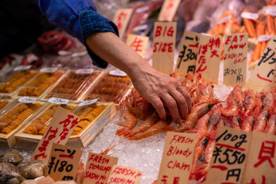 Close up of hand in market selecting fish 