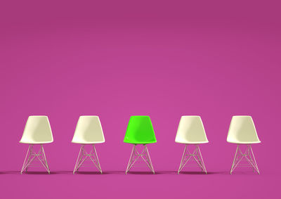 Empty chairs against pink background