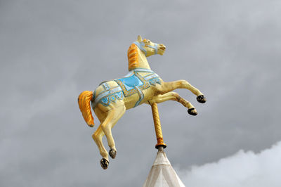 Low angle view of horse representation against sky