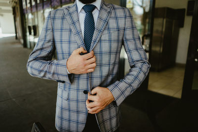 Midsection of businessman in checked pattern suit