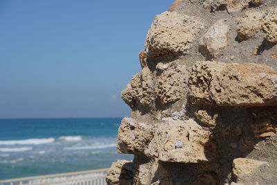 Close-up of rock on beach against sky