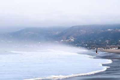 Scenic view of sea and mountains against sky