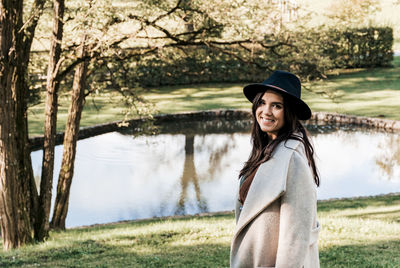 Young woman in fall clothes, coat, hat. looking at camera, smiling.