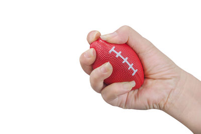 Close-up of hand holding red rose over white background