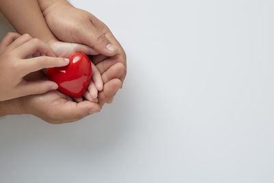 Midsection of woman holding red over white background