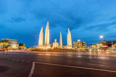 Illuminated city buildings against sky at dusk