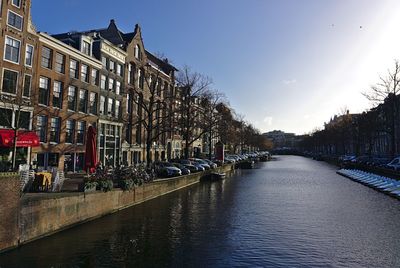 Canal amidst buildings against sky in city