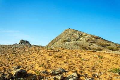 Mountain at desert against clear blue sky