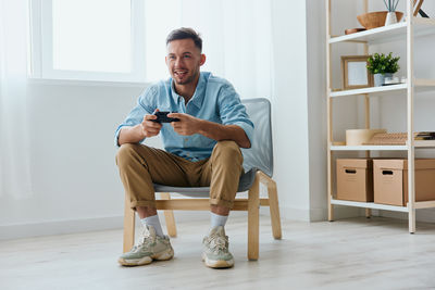 Portrait of young man sitting on floor at home