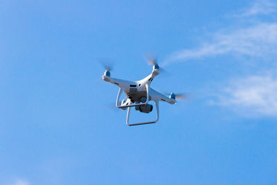 Low angle view of airplane against blue sky