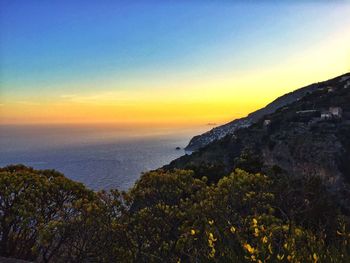 Scenic view of sea and mountains against clear sky