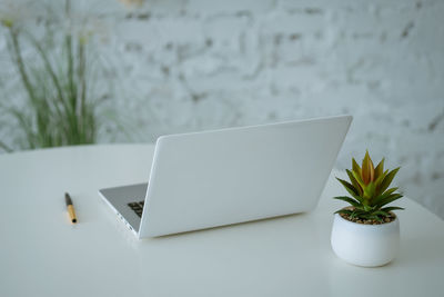 Close-up of white and laptop on table