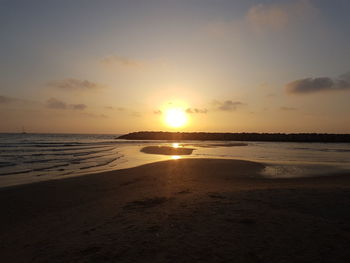 Scenic view of beach against sky during sunset