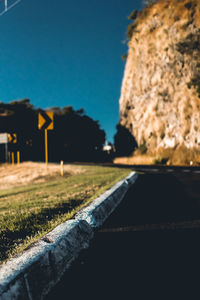 Surface level of road against clear blue sky