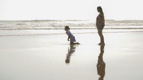 Full length of women on beach against sky