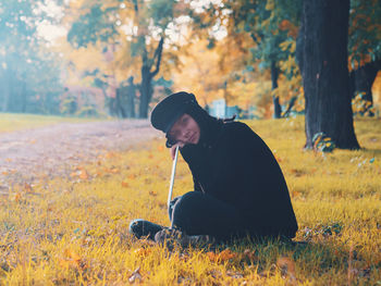Portrait of young woman with laptop at public park during autumn