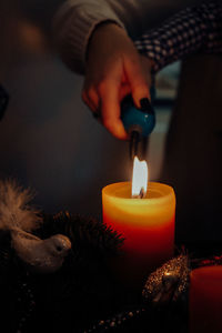 Midsection of man holding lit candle