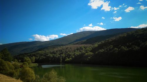 Scenic view of lake and mountains against sky