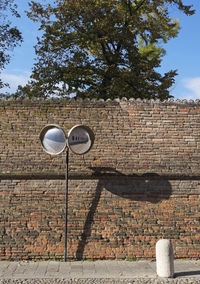 Low angle view of brick wall against trees