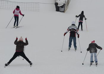 People skiing on snowy field