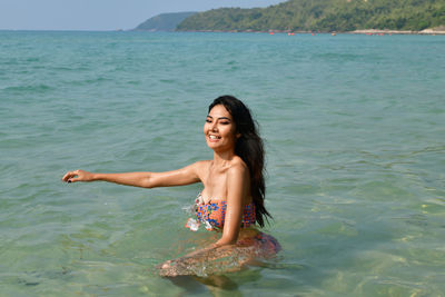 Portrait of smiling young woman in sea