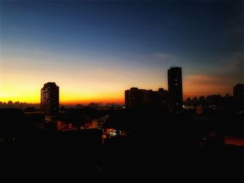 Silhouette buildings against sky during sunset