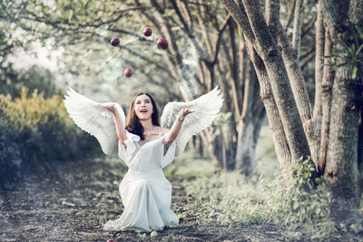 Woman in angel costume throwing fruits on field