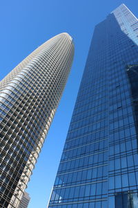Low angle view of modern buildings against clear blue sky