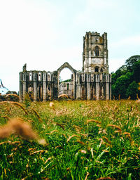 Old ruins on field against sky