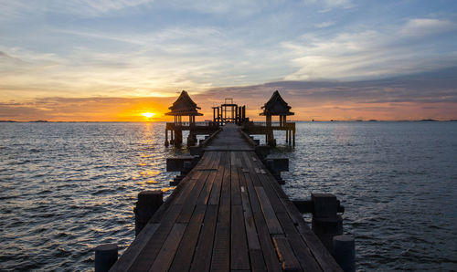 Pier over sea against sky during sunset