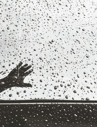 Low section of raindrops on glass