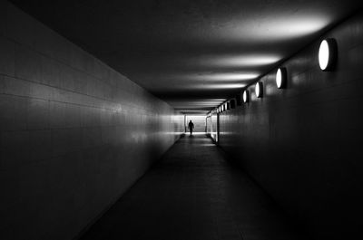 Man walking in illuminated tunnel