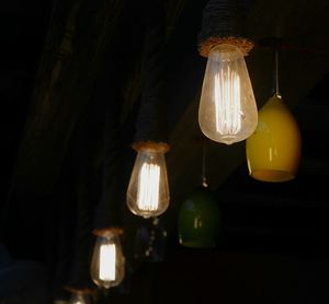 Illuminated light bulb hanging at home