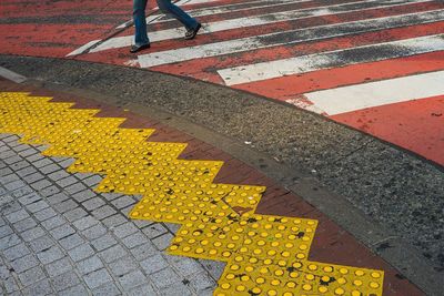 Low section of person crossing road