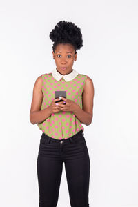 Portrait of mid adult man using smart phone against white background