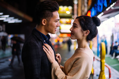 Side view of young couple standing outdoors