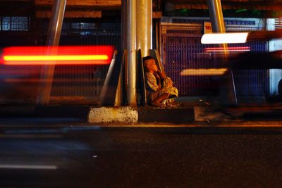 Woman sitting in illuminated city at night