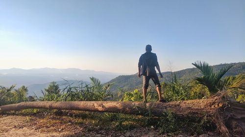 Rear view of man looking at mountain against sky