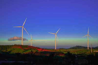 Windmill on field against sky