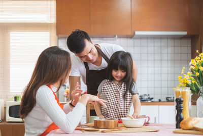 Family preparing food in kitchen at home