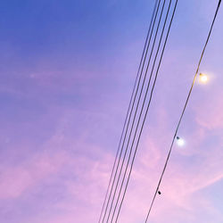 Low angle view of silhouette cables against sky at sunset