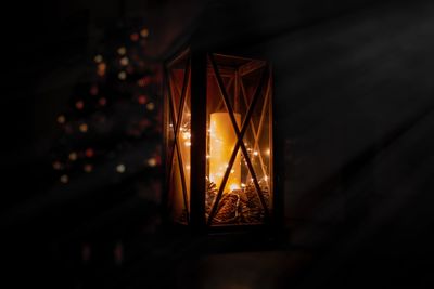 Close-up of illuminated candle in lantern at night