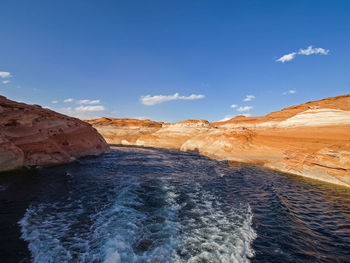 Scenic view of sea and mountains against blue sky