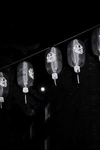 Low angle view of illuminated lanterns hanging by building